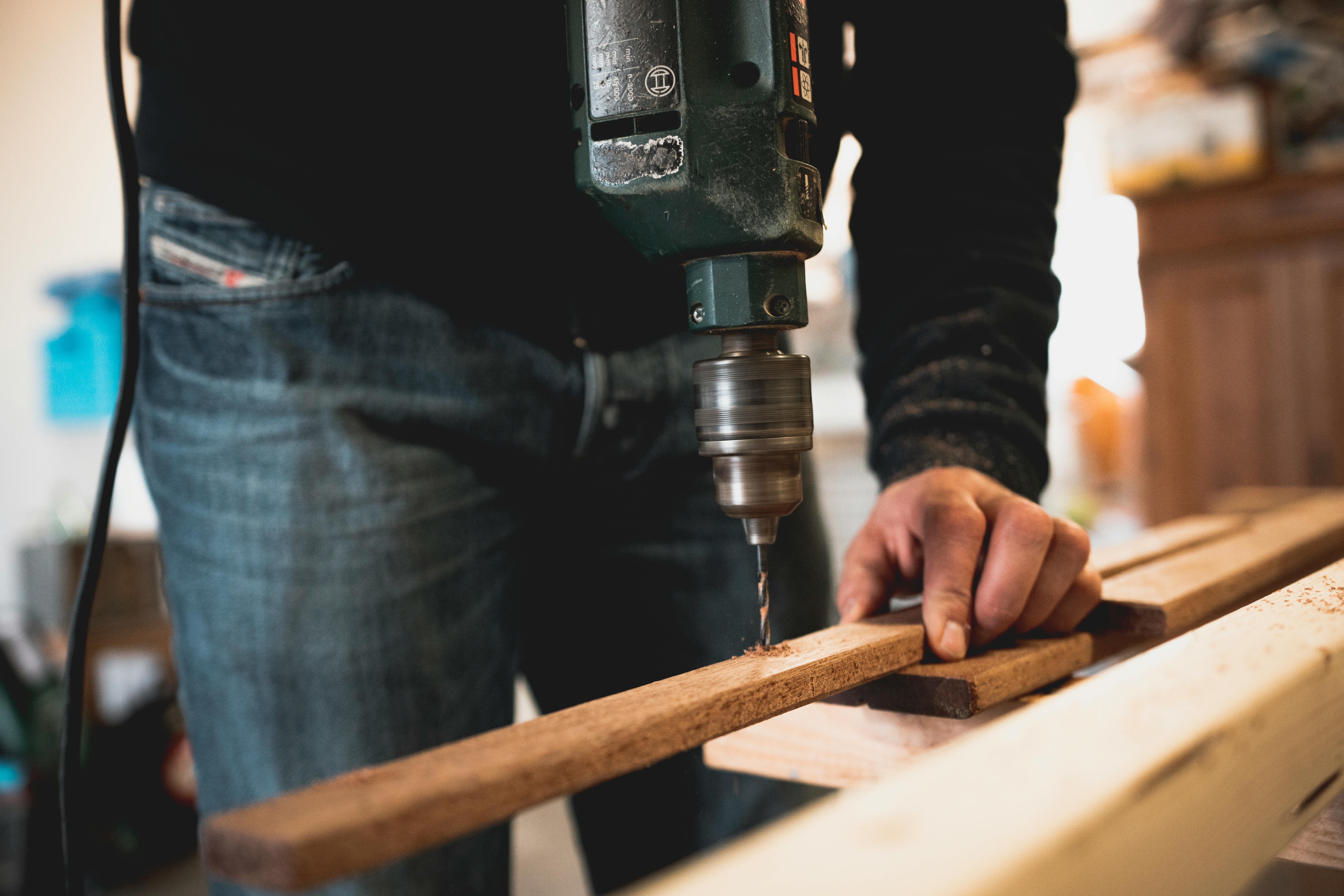 Construction Worker Drilling Into a Piece of Wood